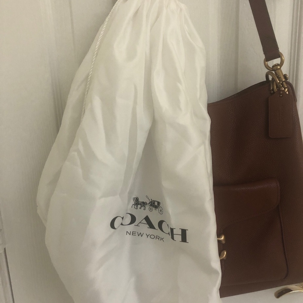 Brown leather coach shoulder bag with original storage bag.